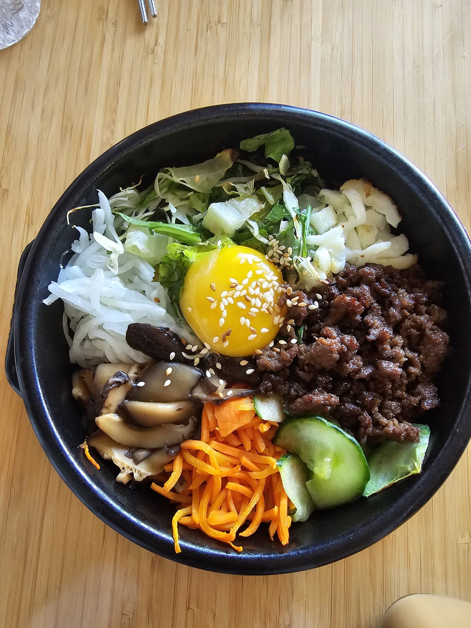 Dolsot bibimbap in a hot stone pot topped with raw egg yolk