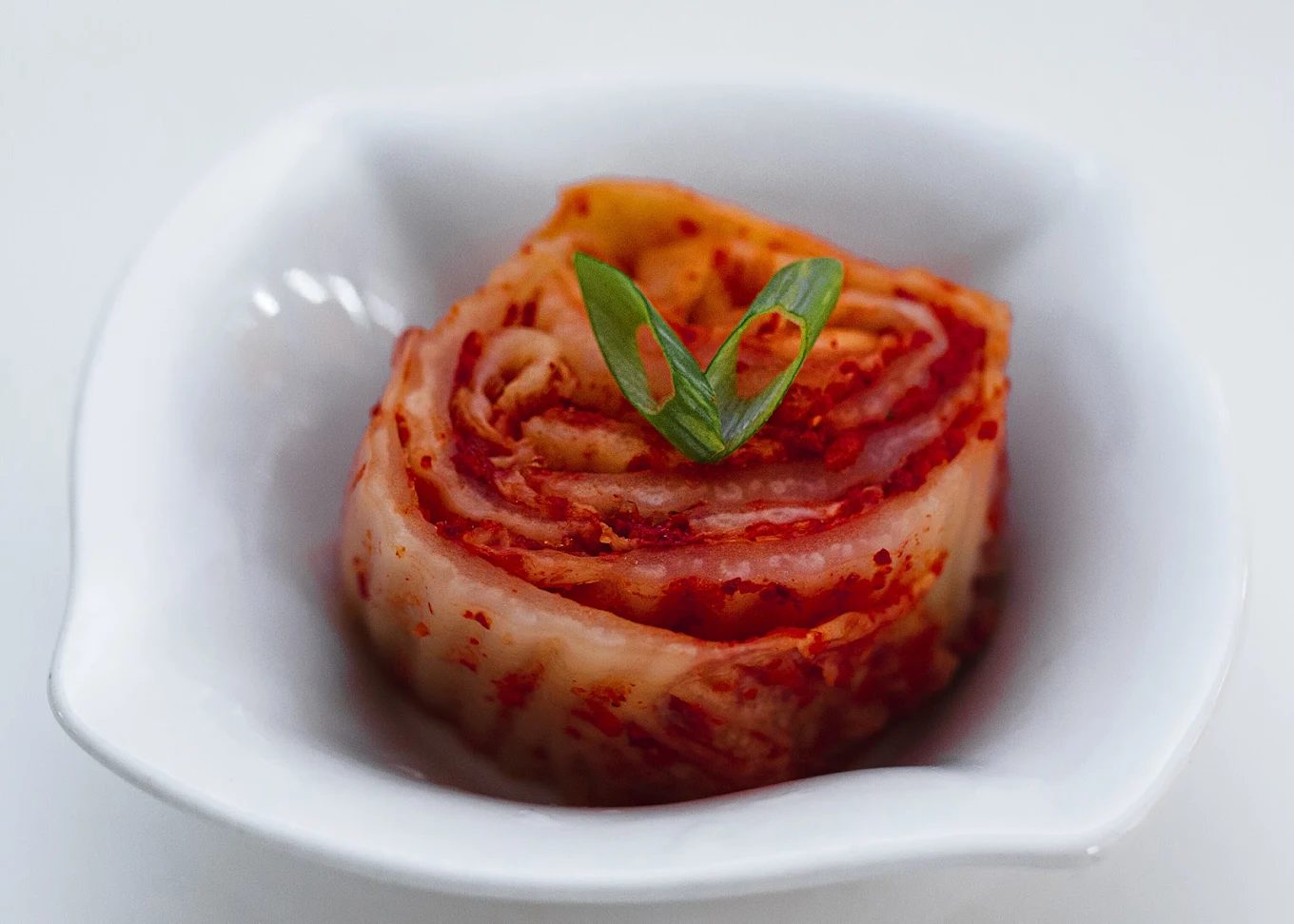 Napa cabbage kimchi in a white bowl