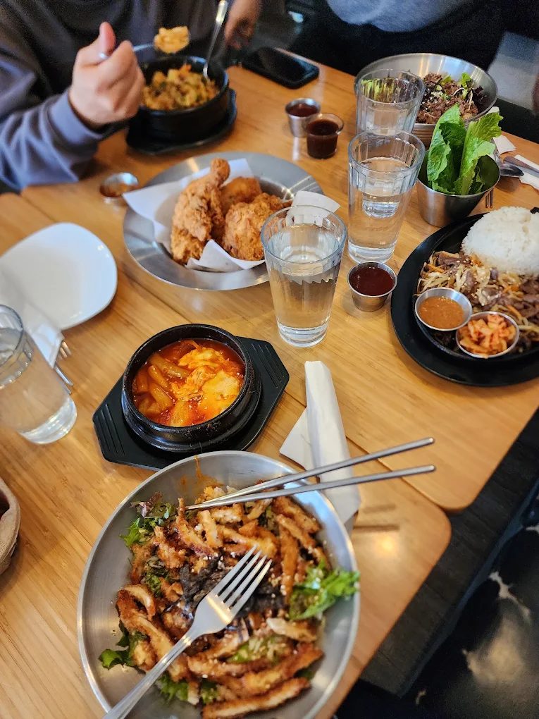 A full table of Haru dishes being shared